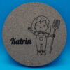 Personalisierbarer Untersetzer aus Kork mit niedlicher Gravur eines lächelnden Mädchens in Latzhose und Heugabel sowie einem individuell wählbaren Namen, hier „Katrin“. Perfekt als originelle Tischdeko, kreatives Geschenk oder persönliche Erinnerung an besondere Anlässe.