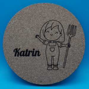 Personalisierbarer Untersetzer aus Kork mit niedlicher Gravur eines lächelnden Mädchens in Latzhose und Heugabel sowie einem individuell wählbaren Namen, hier „Katrin“. Perfekt als originelle Tischdeko, kreatives Geschenk oder persönliche Erinnerung an besondere Anlässe.