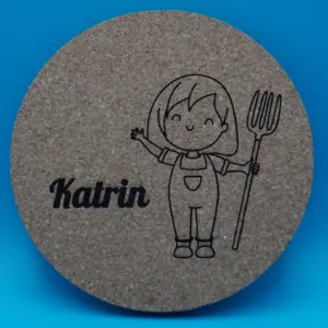 Personalisierbarer Untersetzer aus Kork mit niedlicher Gravur eines lächelnden Mädchens in Latzhose und Heugabel sowie einem individuell wählbaren Namen, hier „Katrin“. Perfekt als originelle Tischdeko, kreatives Geschenk oder persönliche Erinnerung an besondere Anlässe.