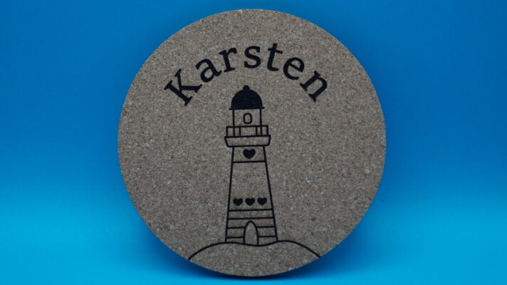 Personalisierter Korkuntersetzer mit Gravur eines stilisierten Leuchtturms und einem individuell wählbaren Namen, hier „Karsten“. Ideal als maritimes Geschenk, dekoratives Highlight oder besondere Erinnerung an Feiern und Anlässe.