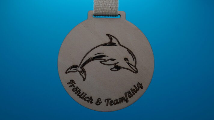 Medaille für Kinder aus Holz mit Delfinmotiv und den Charaktereigenschaften Fröhlich & Teamfähig