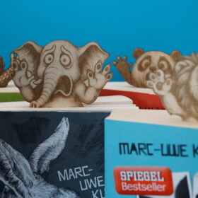 Lesezeichen witzige Tiere - überraschte Gesichter, die vier Tiere (Löwe, Elefant, Panda und Krokodil) schauen überrascht aus den vier Taschenbüchern.